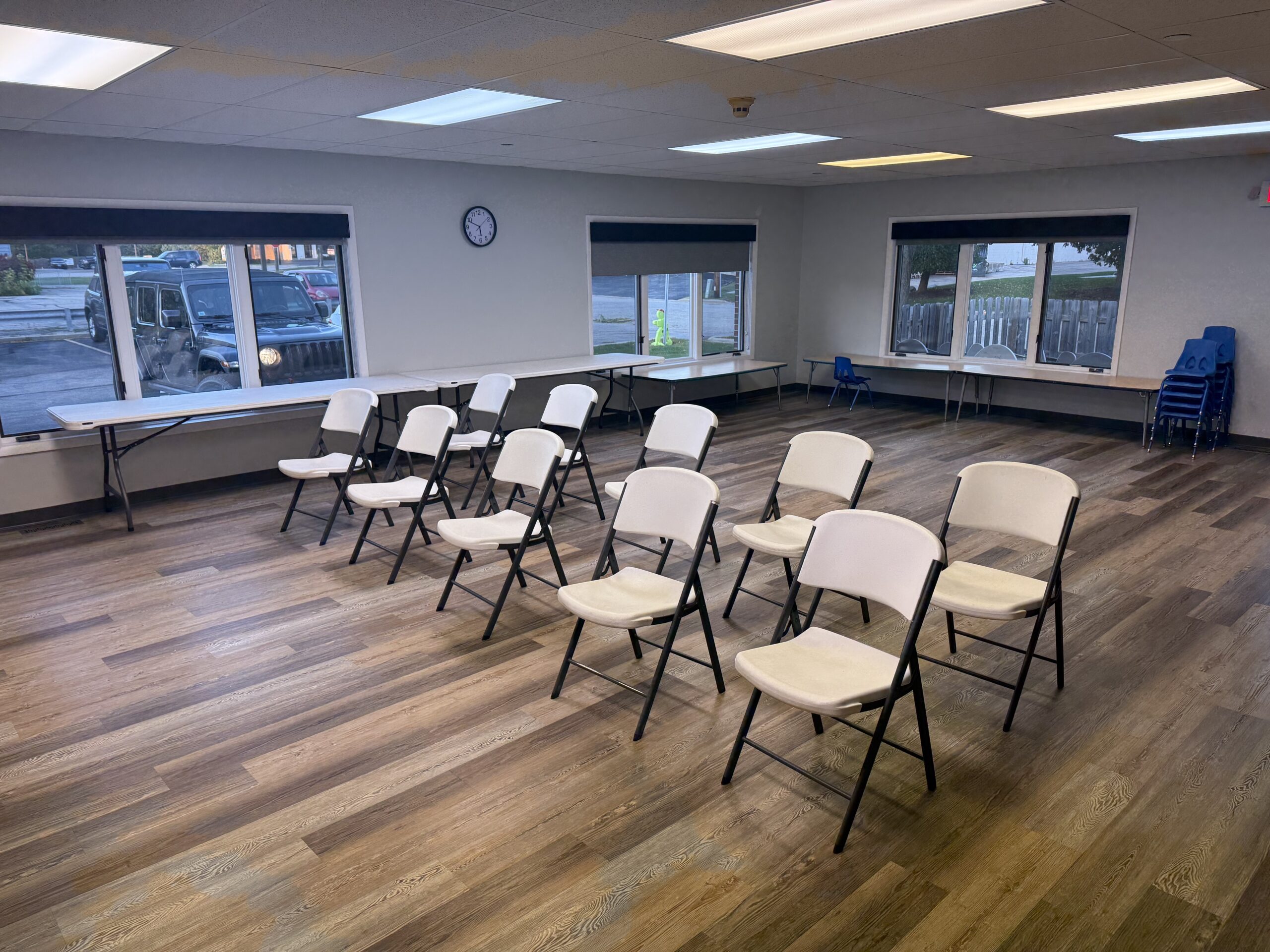 An empty well lit room is set up with table and chairs.