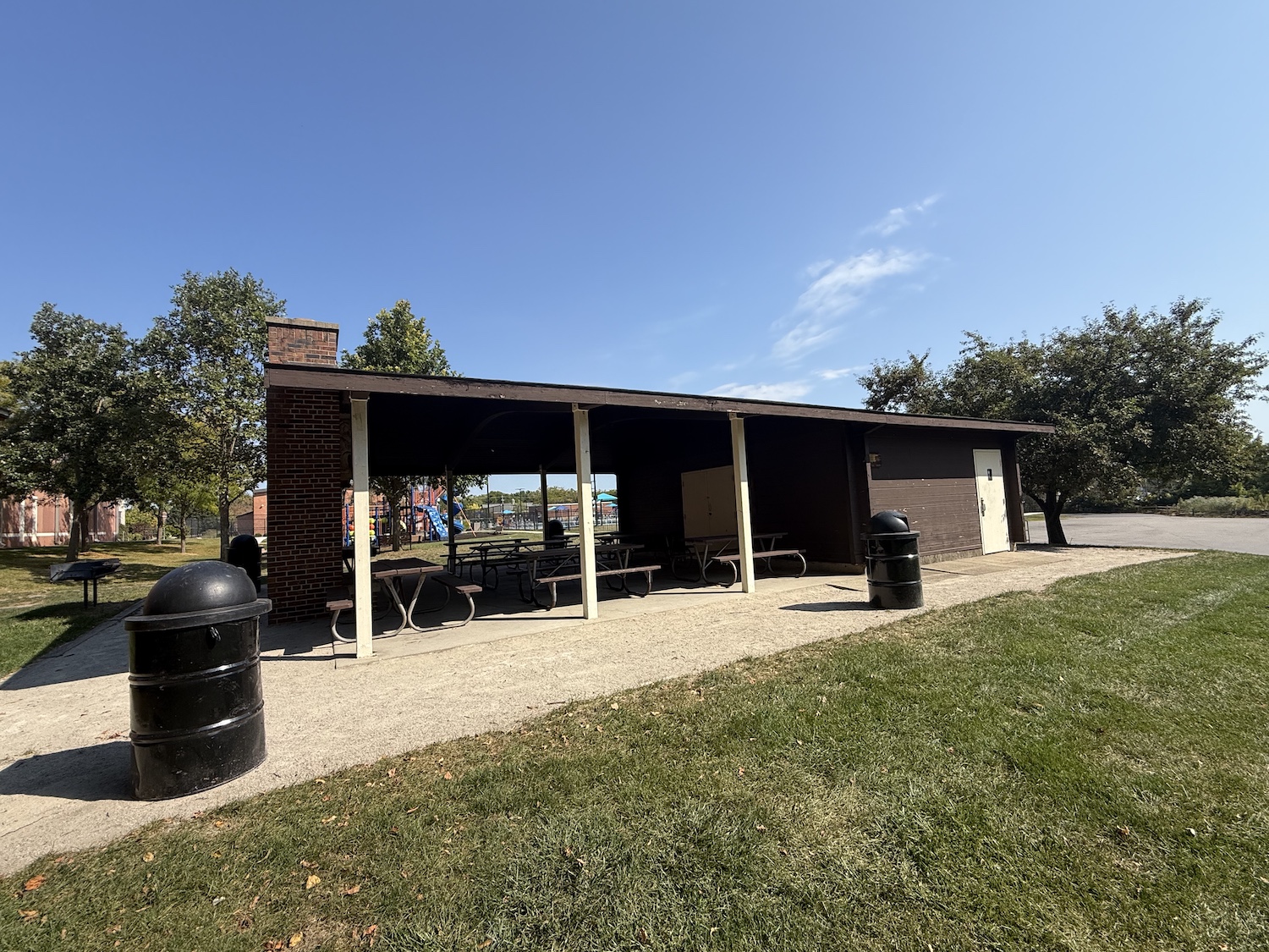 Picnic shelter with restrooms, wooden pavilion, picnic tables, and garbage cans in gavel.