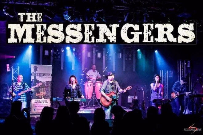 A live band performs on stage, with multiple musicians playing instruments and singing, and the text “The Messengers” displayed above.
